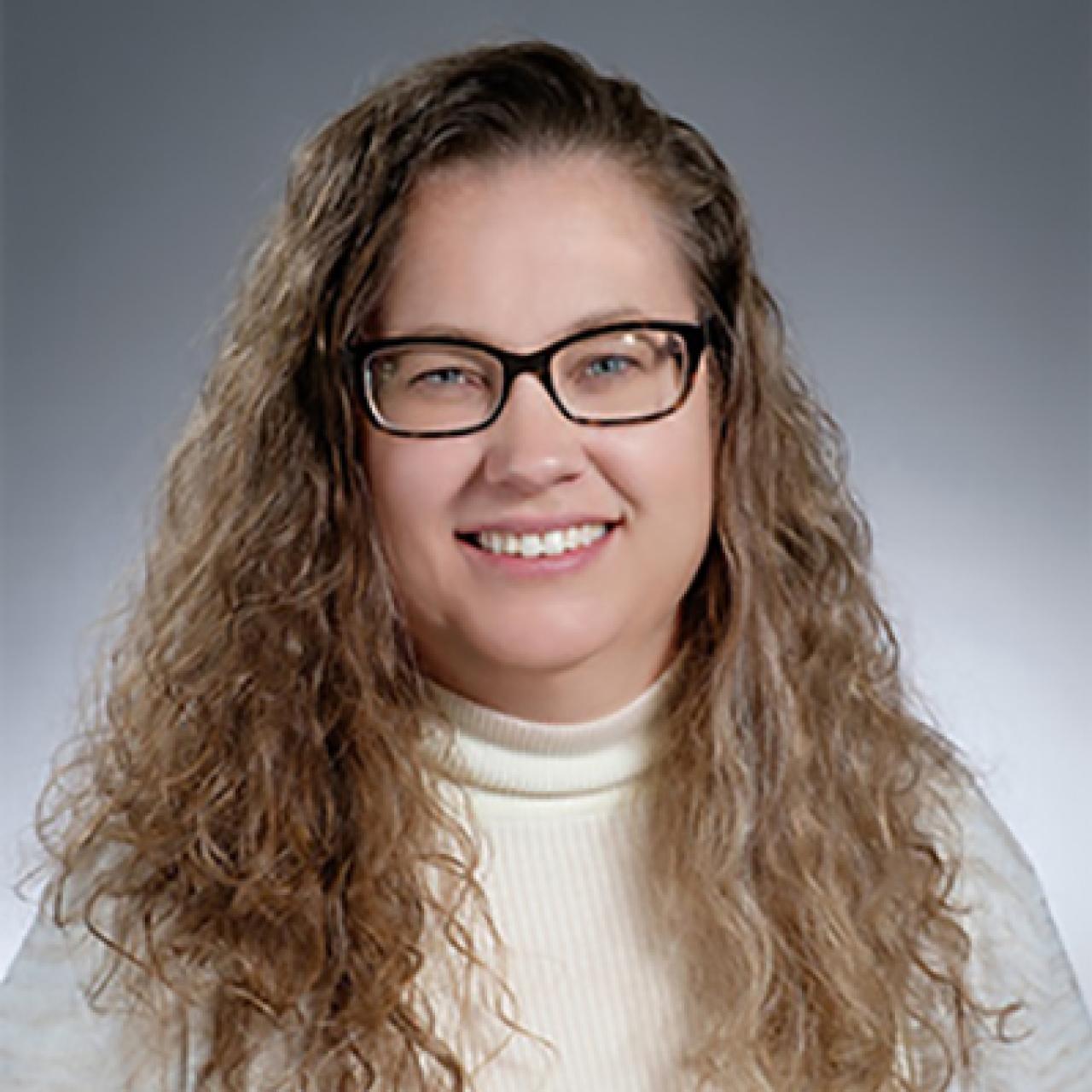 white female with long wavy hair and glasses