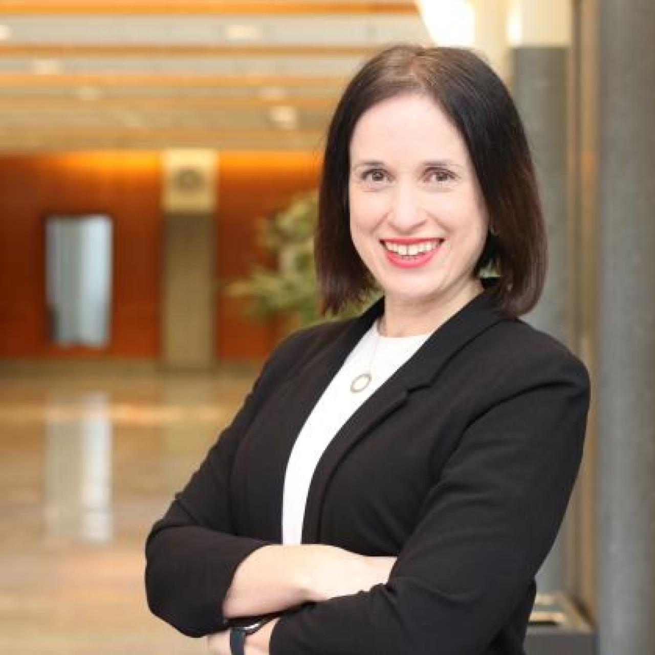 white female with arms crossed and dark hair
