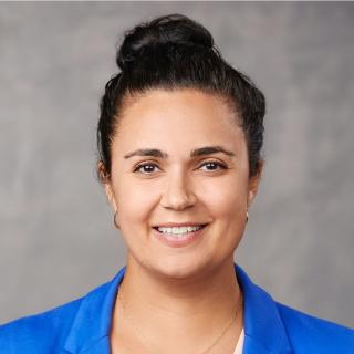 female with dark hair and blue jacket