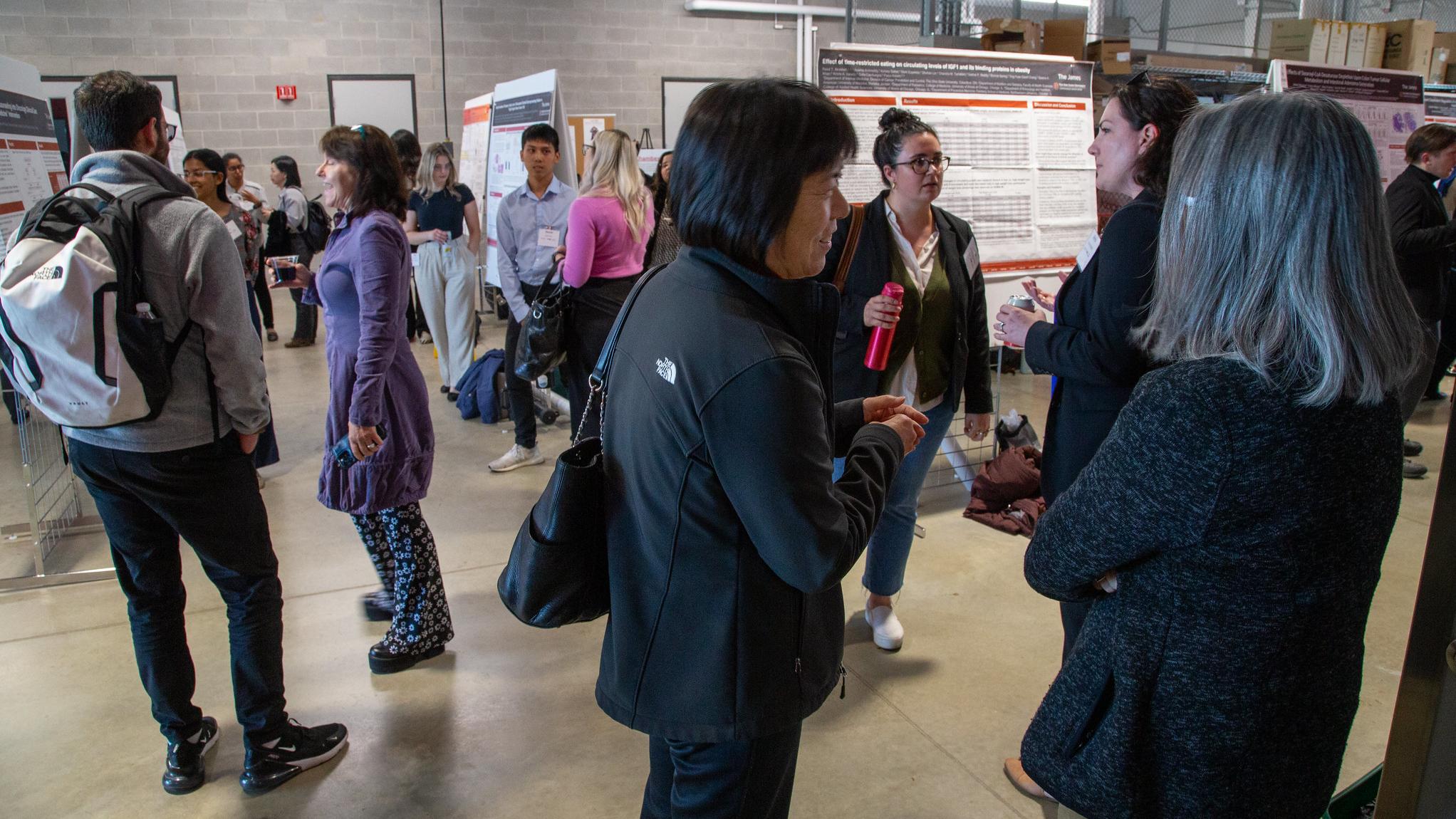 people networking around research posters
